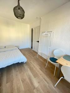 een slaapkamer met een bed, een bureau en een tafel bij Studio au cœur de Chabeuil in Chabeuil