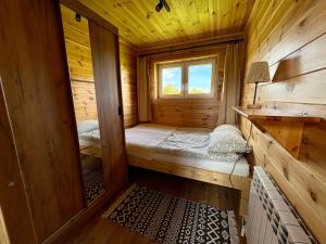 a small room with two beds in a wooden cabin at Beskid Barns - Domek z Balią i Widokiem na Babią Górę in Jordanów