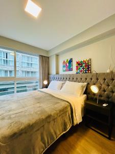 a bedroom with a large bed and a large window at Vita Boulevard Gramado in Gramado