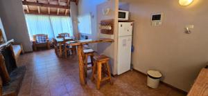 a kitchen with a refrigerator and a table and chairs at CABAÑAS CON COSTA DE LAGO en CIRSE in San Carlos de Bariloche +11 photos
