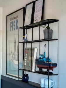 a shelf with a toy boat and books on it at Seaside Retreat & Hotel in Stege
