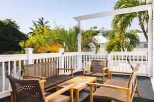 a deck with chairs and a wooden table and chairs at Creme Brulee Suite in Key West +4 photos