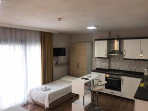 a small bedroom with a bed and a kitchen at laisla apart otel in Kusadası