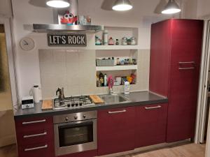 Una cocina con gabinetes rojos y un fregadero. en Dario's Trumpet, en Milán