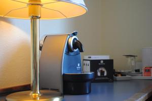 eine Kaffeemaschine auf einem Tisch neben einer Lampe in der Unterkunft Hotel am Rosengarten in Bad Wimpfen