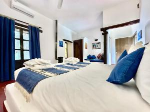 1 cama blanca grande con almohadas azules en una habitación en La Bergerie Ouirgane - Serenity Lodge, en Asni