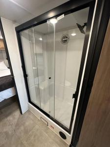 a glass shower door in a room with a bedroom at Buffalo Drift Tiny Home in Interior +12 photos