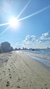 a sandy beach with the sun in the sky at Pousada JOSHUA in Penha