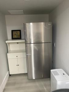 eine Küche mit einem Kühlschrank aus Edelstahl in einem Zimmer in der Unterkunft Dunique unique home in Winnipeg