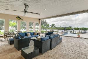 un salon avec un mobilier bleu et une piscine dans l'établissement Waterfront Arcadia Home with Dock on Peace River, à Harbour Heights