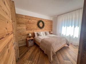 a bedroom with a bed and a wooden wall at Sognatrentino in Cialini