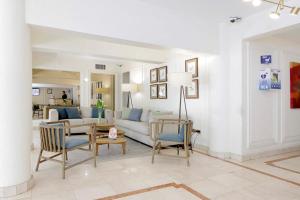 a living room with a couch and a table and chairs at MR Express (ex Hotel Neruda Express) in Santiago