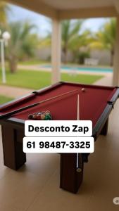 a pool table with a sign that reads cocaine zap at A Casa Paradisíaca Total Luxuoso Piscina Super Hiper Mega Quente 50 graus Aquecimento Elétrico , Sinuca e 5 Quartos Com Ar Condicionado Com Roupa de Cama e Banho in Caldas Novas