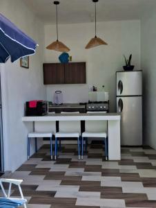a kitchen with a table and a refrigerator at Apartamento de playa con piscina privada in Monterrico