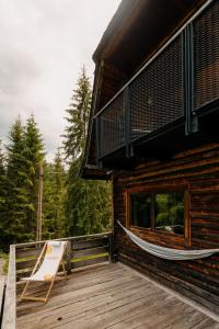 a porch of a log cabin with a hammock on it at Chalet les deux freres in Fundăţica