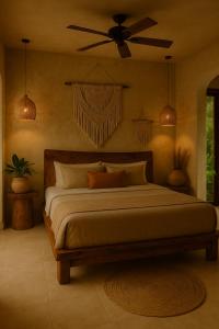 a bedroom with a large bed with a ceiling fan at Aluxes Bacalar in Bacalar