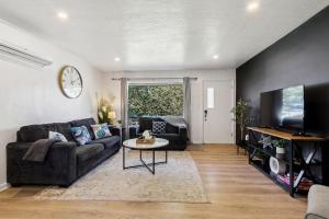 een woonkamer met een bank en een tv bij 2BR with Private Hot Tub in Parma Heights