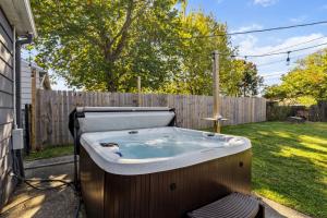 een ligbad in een tuin naast een hek bij 2BR with Private Hot Tub in Parma Heights
