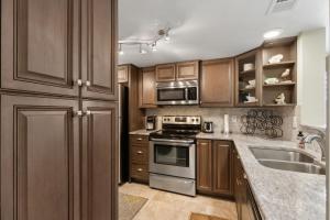 a kitchen with wooden cabinets and stainless steel appliances at Beautiful Corner Oceanfront 2-bedroom, 2 bath Condo in Amelia Surf & Racquet in Amelia Island