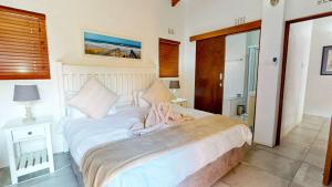 Un dormitorio con una gran cama blanca con toallas. en Lake House at San Lameer, en Southbroom
