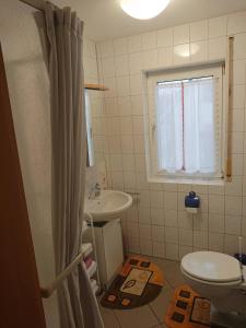 a bathroom with a sink and a toilet and a window at Ferienwohnung Erlangen Urlaub mitten in Franken in Wachenroth