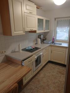 a kitchen with white cabinets and a counter top at Ferienwohnung Erlangen Urlaub mitten in Franken in Wachenroth