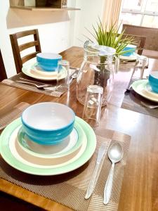 einem Holztisch mit Tellern und Besteck in der Unterkunft Amplio y Acogedor, cerca al parque de las aguas in Víctor Larco Herrera + 4 Fotos