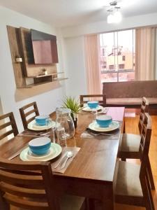 ein Esstisch aus Holz mit blauem Geschirr darauf in der Unterkunft Amplio y Acogedor, cerca al parque de las aguas in Víctor Larco Herrera