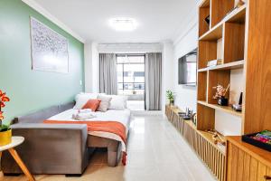 a living room with a bed and a couch at Flat espaçoso, no Manaíra, com varanda ampla, a 100m da praia e ao lado do Mag Shopping in João Pessoa