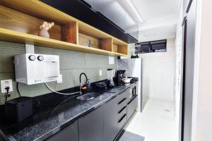 a kitchen with a sink and a microwave at Flat espaçoso, no Manaíra, com varanda ampla, a 100m da praia e ao lado do Mag Shopping in João Pessoa