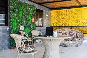 a patio with a table and chairs with a laptop at Flat espaçoso, no Manaíra, com varanda ampla, a 100m da praia e ao lado do Mag Shopping in João Pessoa +37 photos