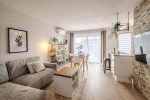 a living room with a couch and a table at La Résidence Fleurie, vue sur le Lac Léman in Thonon-les-Bains