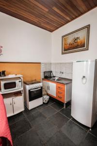 a kitchen with a refrigerator and a stove top oven at Chalé Suiço de Campos do Jordão in Campos do Jordão