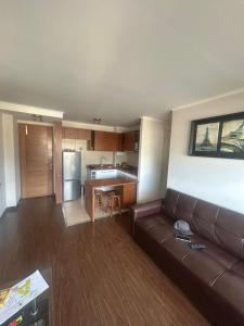 a living room with a couch and a kitchen at Departamentokilaman in Concepción