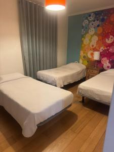 a room with two beds and a painting on the wall at Triple room in a House with a pool in Quejas