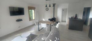 a living room with a couch and a table at Maison à 5 min de la plage in Hervelinghen +2 photos