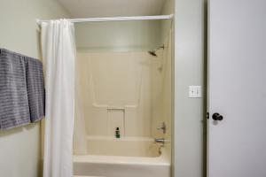 a bathroom with a shower with a white shower curtain at 1 Mi to Shops and Cafes Updated Cassville Home! in Cassville +22 photos