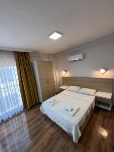 a hotel room with a bed and a window at laisla apart otel in Kusadası