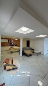 a large living room with couches and a table at Maison f2 rouge in Saint-Leu