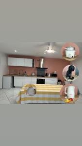 a kitchen with pink walls and white cabinets at Maison f2 rouge in Saint-Leu