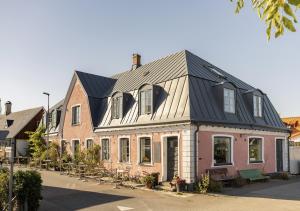 a house with a black roof on a street at Hörnan på Brantevik in Brantevik