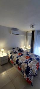 une chambre avec un lit avec une couette colorée dans l'établissement BenalBacko, Apartment in Arroyo de la Miel, Benalmádena, à Benalmádena