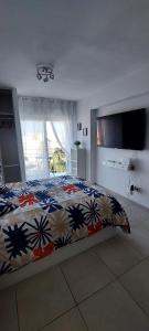 une chambre avec un lit avec une couette colorée dans l'établissement BenalBacko, Apartment in Arroyo de la Miel, Benalmádena, à Benalmádena