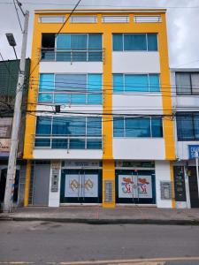 Estación El SaltoにあるHotel Boutique Bogotá Eliteの通路脇の黄白の建物