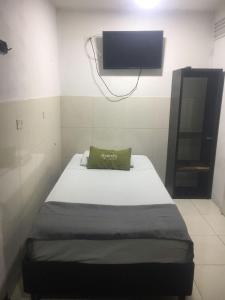 Estación El SaltoにあるHotel Boutique Bogotá Eliteのベッド1台、壁掛けテレビが備わる小さな客室です。