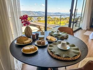 a table with plates of food on it with a view at Cabana Encanto do Sapucaí in São Bento do Sapucaí