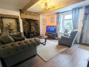 ein Wohnzimmer mit Couch und Fernseher in der Unterkunft Beautiful Waterfall Cottage with Countryside Walks in Barnoldswick