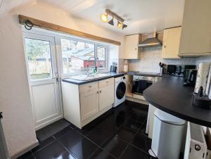 eine kleine Küche mit Spüle und Fenster in der Unterkunft Beautiful Waterfall Cottage with Countryside Walks in Barnoldswick