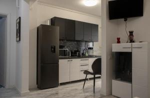 a kitchen with a refrigerator and a chair in it at Andra Rezidence in Popeşti-Leordeni