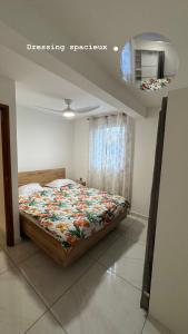 a bedroom with a bed with a colorful blanket at Maison f2 rouge in Saint-Leu